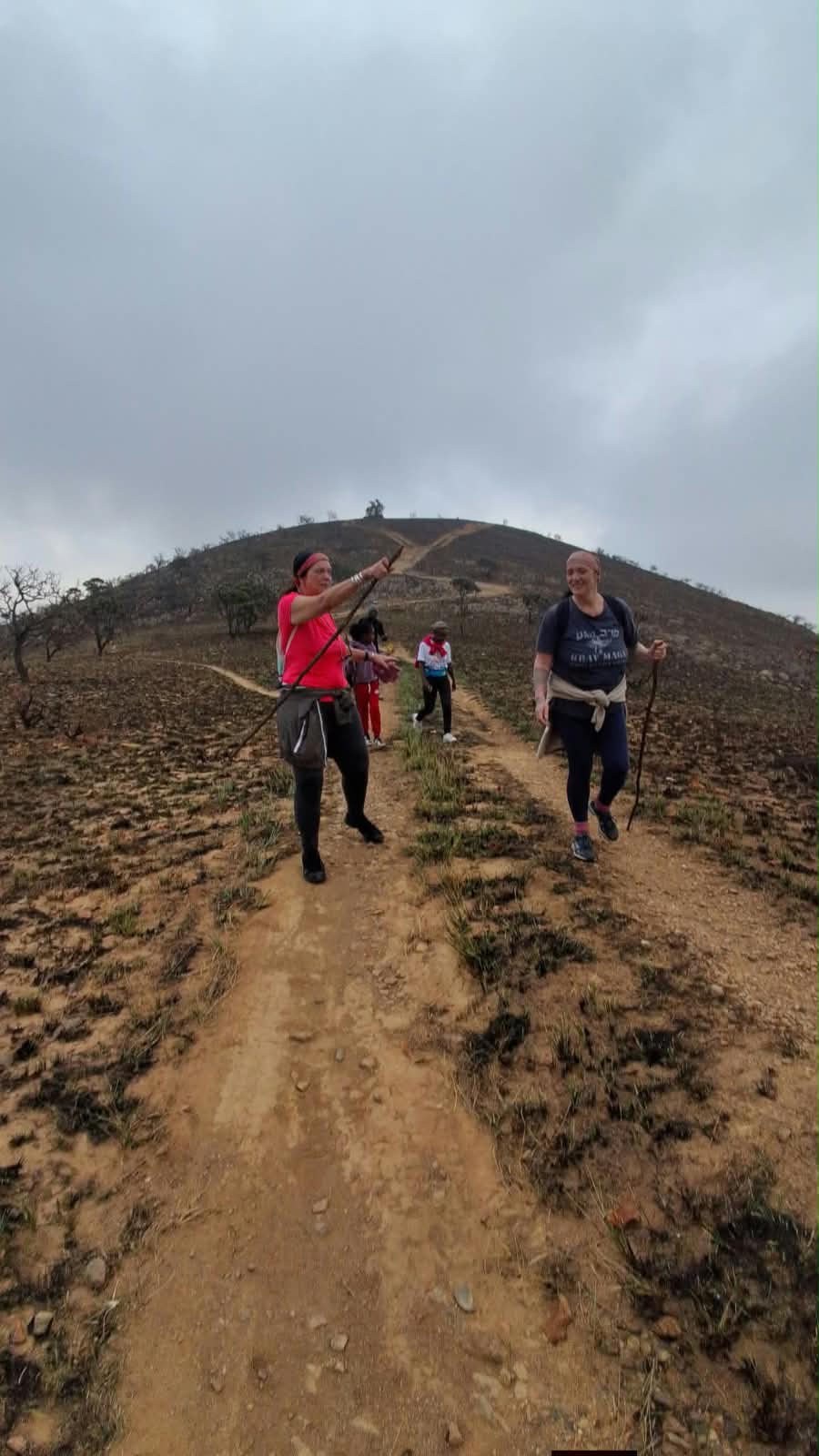 Two hikers pushing to the summit on an overcast Genesis Route morning
